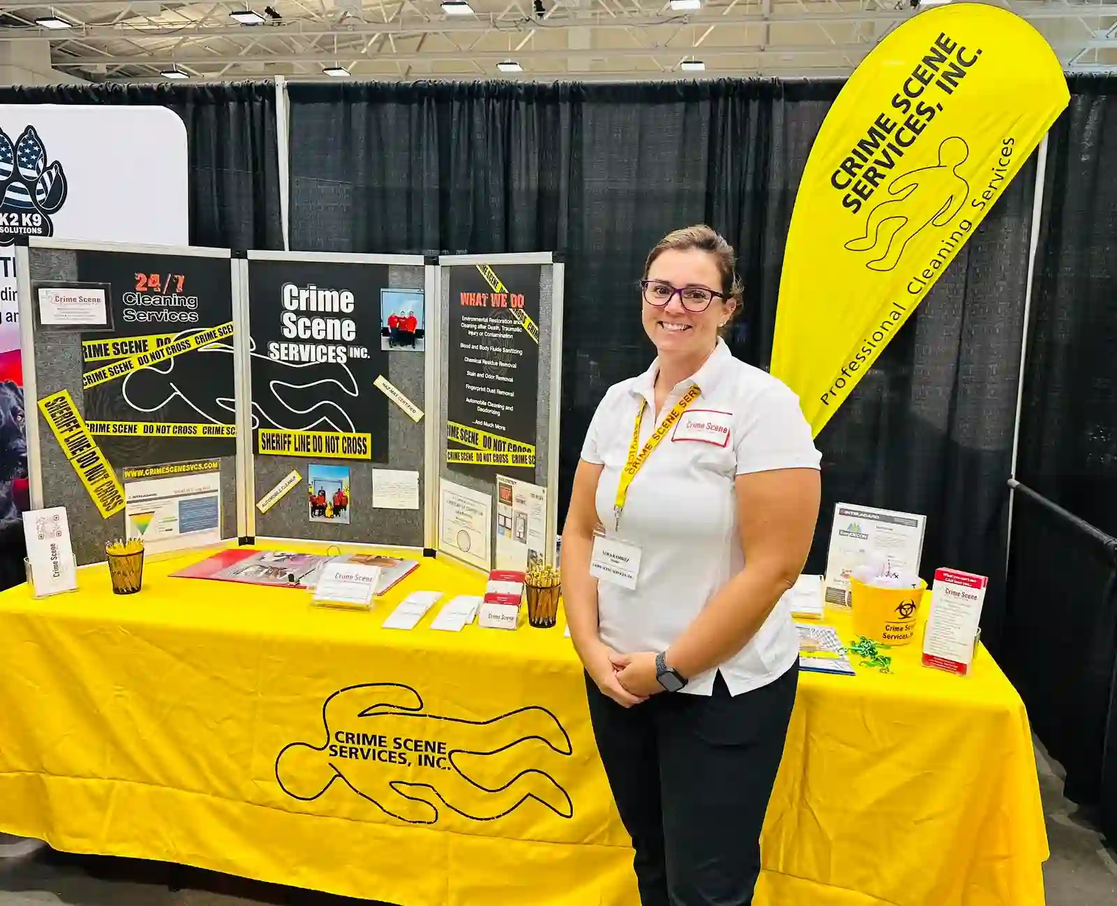 Representative of Crime Scene Services, Inc. standing at professional biohazard and crime scene cleaning services booth during industry trade show event